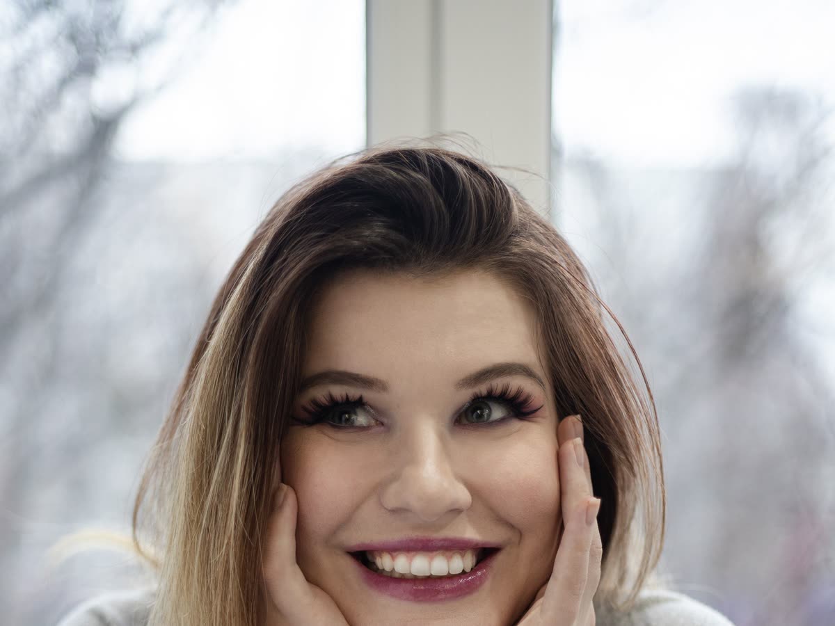 Leende person i fönsterljus